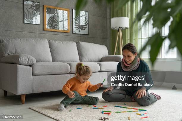 early childhood development. mom & kid play with magnet toys. family time - two magnets stock pictures, royalty-free photos & images