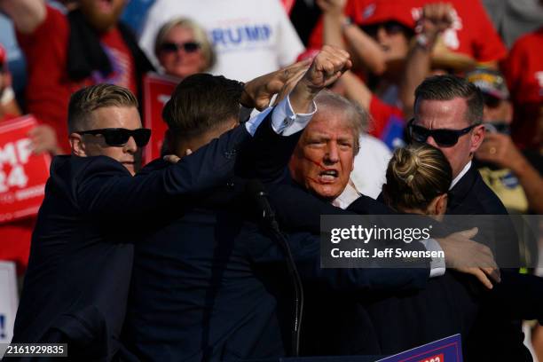 Secret Service agents surround Republican presidential candidate former President Donald Trump onstage after he was injured at a rally on July 13,...