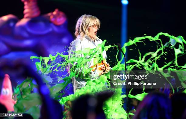 Reneé Rapp gets slimed while accepting the Favorite Breakout Artist award onstage during the Nickelodeon Kids' Choice Awards 2024 at Barker Hangar on...