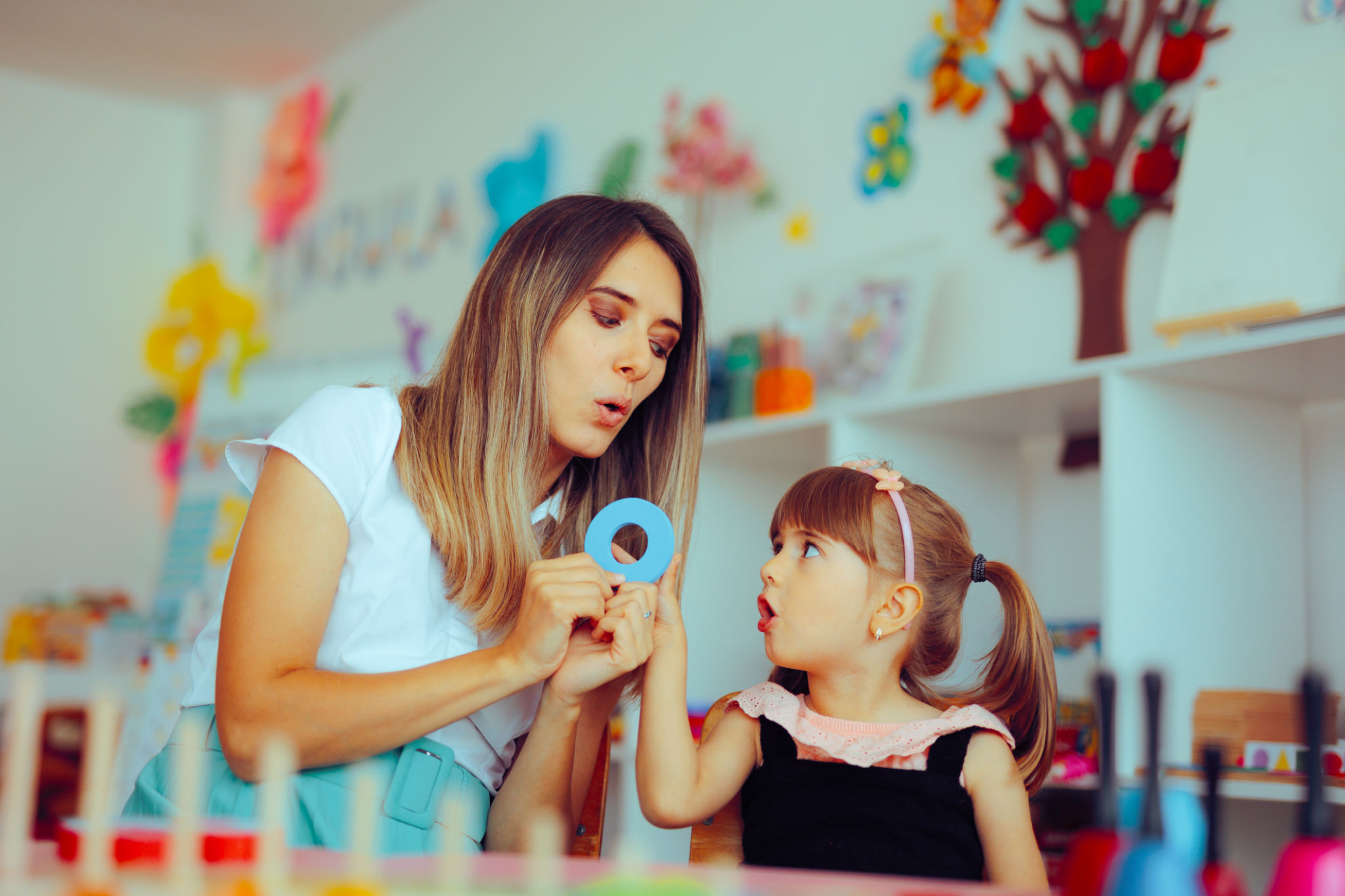 Speech Therapist Teaching a Child the Correct Pronunciation Speech Therapist Teaching a Child the Correct Pronunciation
