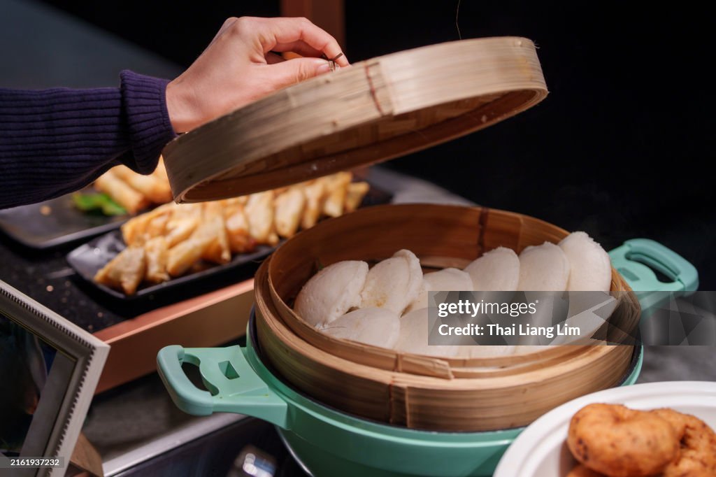 Various selections of Asian food are served on warm chafing dishes for heating food in a hotel restaurant buffet banquet.