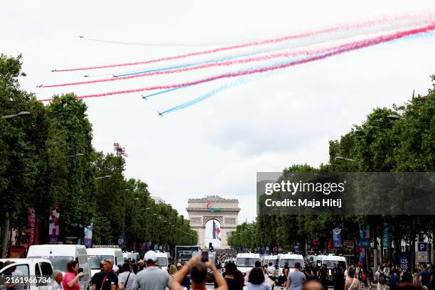 Military airplanes fly over the Arc de Triomphe showing the colours of the national flag of France on July 14, 2024 in Paris, France. The Olympic...