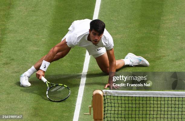 Carlos Alcaraz of Spain slides to play a forehand against Novak Djokovic of Serbia in the Gentlemen's Singles Final during day fourteen of The...