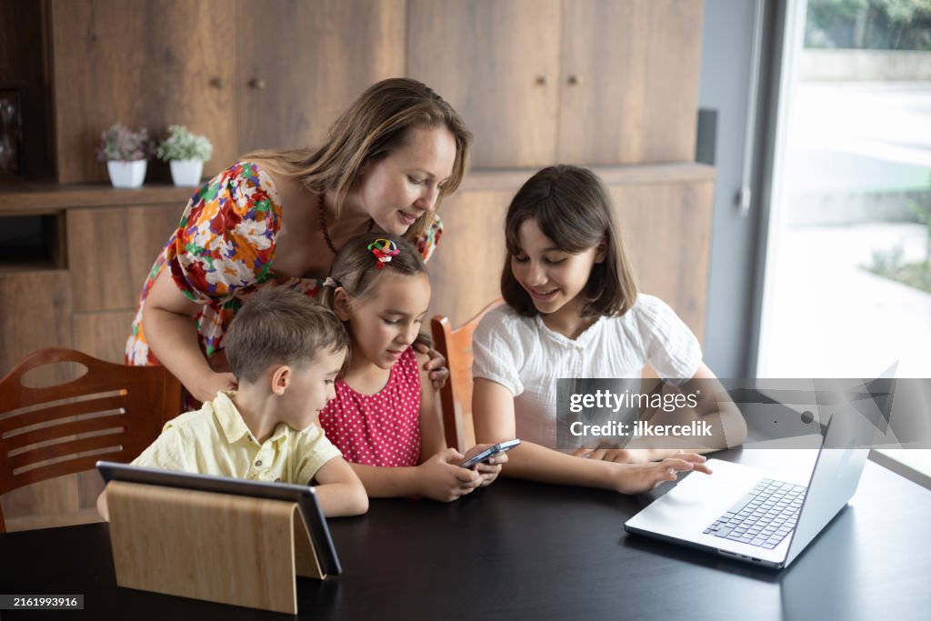 3 Kids Using Computer Mother And Three Children Using Laptop Computer Digital Tablet And ...