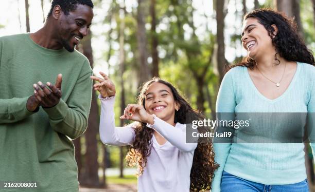 multirassisches mädchen mit mutter und freund, tanzend im park - person gemischter abstammung stock-fotos und bilder