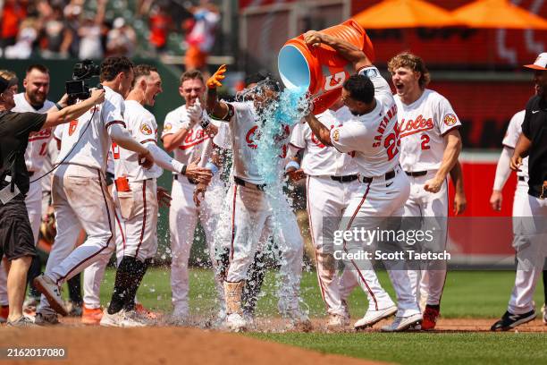 Anthony Santander of the Baltimore Orioles dumps Gatorade on Cedric Mullins after Mullins hits a two RBI double against Clay Holmes of the New York...