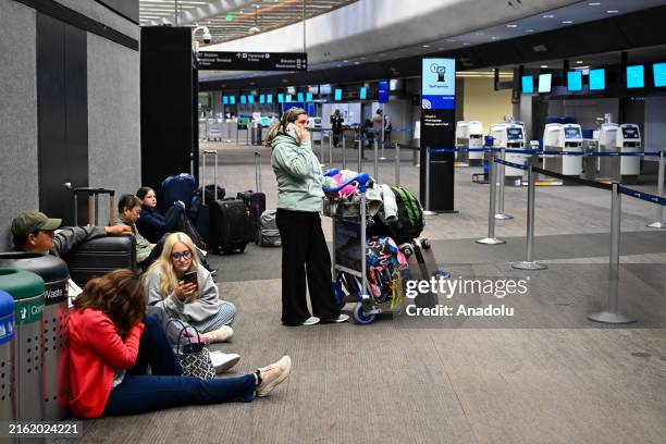 Passengers await by the United Airlines check-in counter as the flights canceled due to major Microsoft IT outage, at San Francisco International...