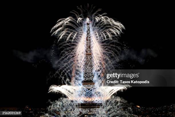 Drone and firework show lights up the Eiffel Tower on July 14, 2024 in Paris, France. The Olympic Flame arrived in Paris on July 14 to be integrated...