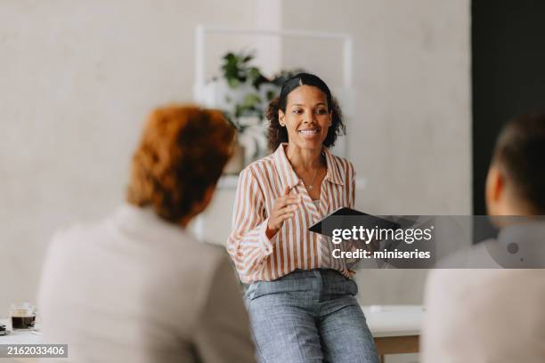 reunión de negocios grupal en una oficina de color beige brillante - estrategia fotografías e imágenes de stock