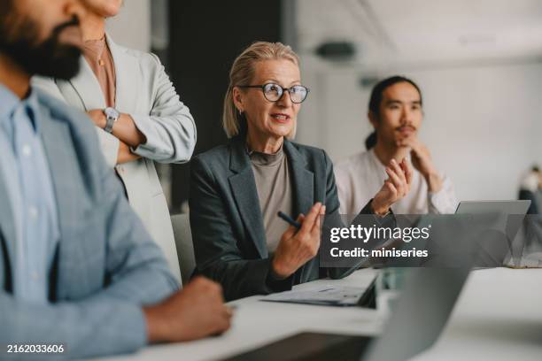 diverse group of professionals in a business meeting at bright office - thought leader stock pictures, royalty-free photos & images