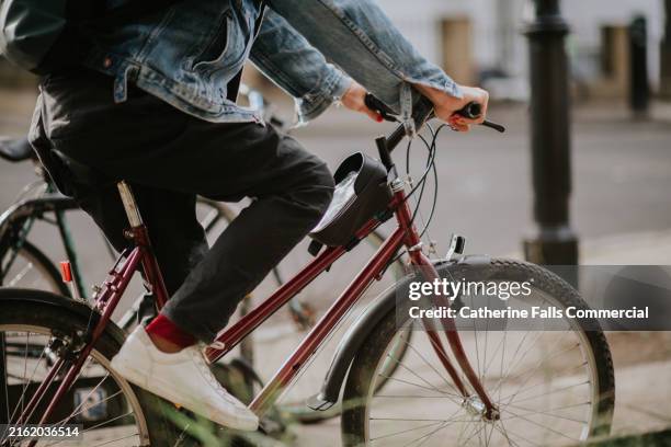 a man commutes to work in a uk city on a manual pedal bike - fahrradlenker stock-fotos und bilder