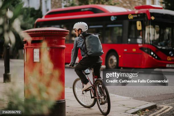 a man commutes to work in a uk city on a manual pedal bike - openbare brievenbus stockfoto's en -beelden
