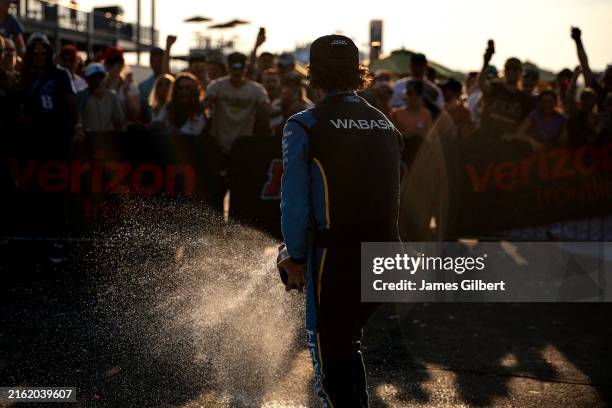 Ryan Blaney, driver of the Wabash Ford, sprays champagne in victory lane after winning the NASCAR Cup Series The Great American Getaway 400 Presented...