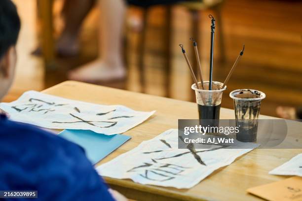 der schüler übt grundlegende chinesische kalligraphie im klassenzimmer - chinesisches schriftzeichen stock-fotos und bilder