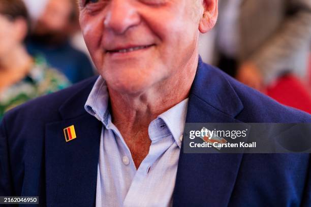 Man wears a jacket with stickers with the logo AfD and german flag-colors as supporters of the far-right Alternative for Germany political party...