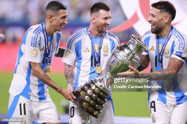 Angel Di Maria, Lionel Messi and Nicolas Otamendi of Argentina hold the trophy after the team's victory in the CONMEBOL Copa America 2024 Final match...