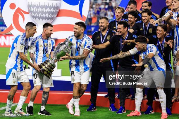 Angel Di Maria, Lionel Messi and Nicolas Otamendi of Argentina celebrate with the trophy after the team's victory in the CONMEBOL Copa America 2024...