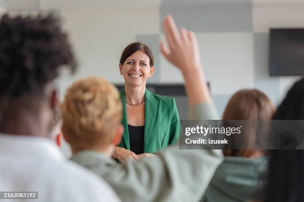 female teacher giving presentation to university students - palestra imagens e fotografias de stock