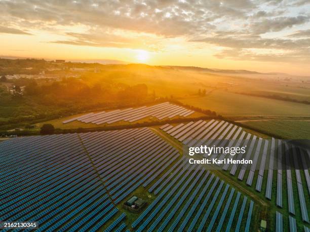 an aerial view of solar panels at sunrise - solar panel stock pictures, royalty-free photos & images