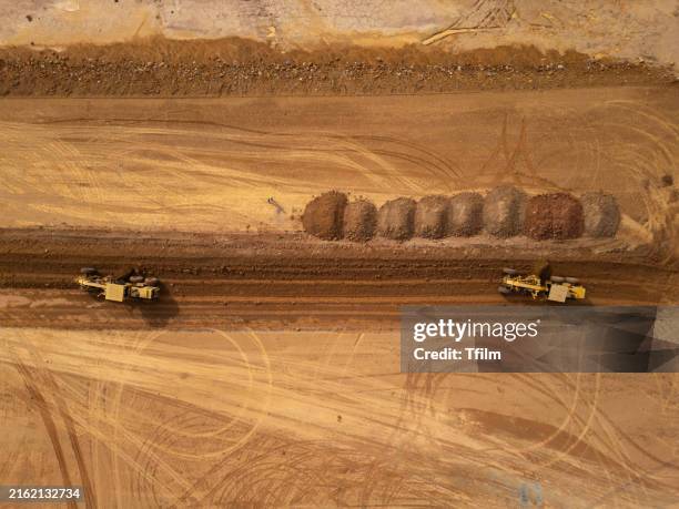 aerial view of earthmoving operations at construction site - movimiento de tierras fotografías e imágenes de stock