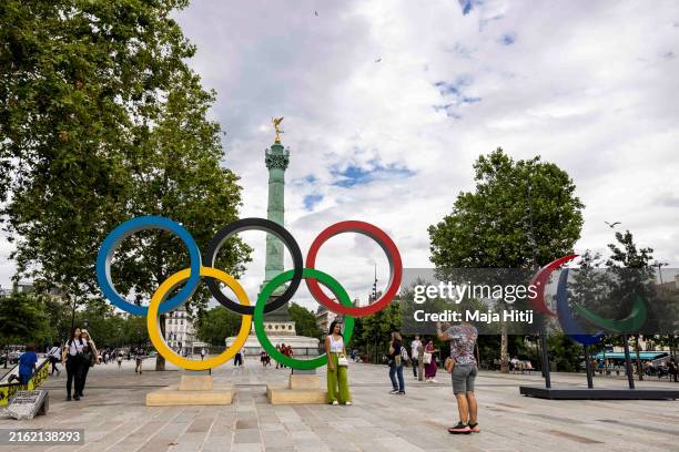Visitors take photos next to Olympic and Paraolympic rings near Plaza de la Bastilla ahead of Paris 2024 Olympic Games on July 15, 2024 in Paris,...