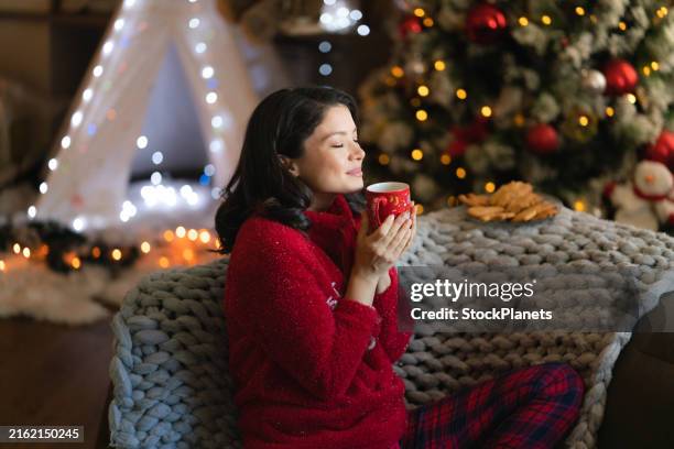 woman enjoys the scent of coffee during christmas at home - cosy christmas stock pictures, royalty-free photos & images