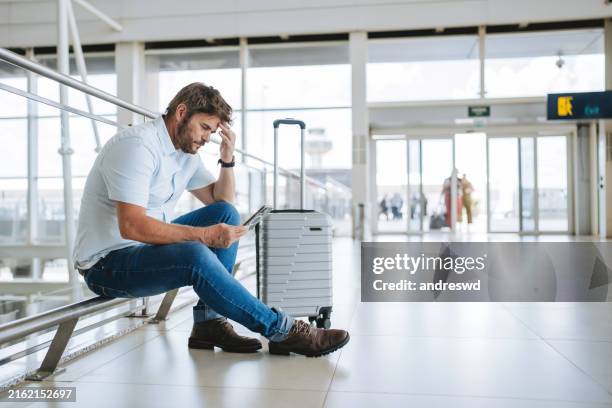 man at the airport waiting for boarding - cancelamento imagens e fotografias de stock