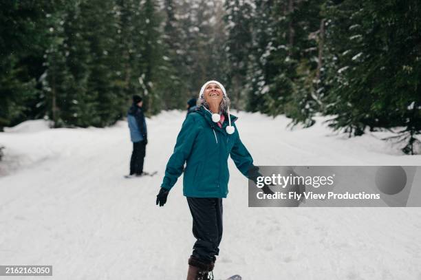 senior woman smiles while snowshoeing - the snow walker stock pictures, royalty-free photos & images