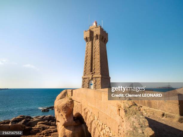 wide angle view of a bridge in front of the mean ruz lighthouse (or ploumanach lighthouse), a famous spot in the sentier des douaniers, in the cote de granit rose (pink granite coast), ploumana'ch - cotes-d'armor - bretagne (brittany), western france. - bodenmarkierung stock-fotos und bilder