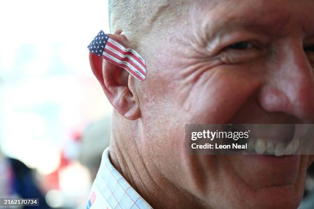 Person is seen with an adhesive bandage with a design of the American flag on his ear on the first day of the Republican National Convention at the...