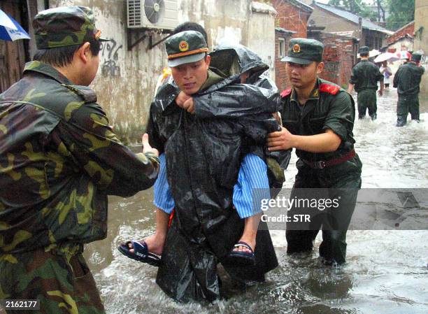 Chinese soldiers rescue a resident of Yangzhou in eastern China's Jiangsu province 05 July 2003. Officials in the eastern province of Anhui evacuated...