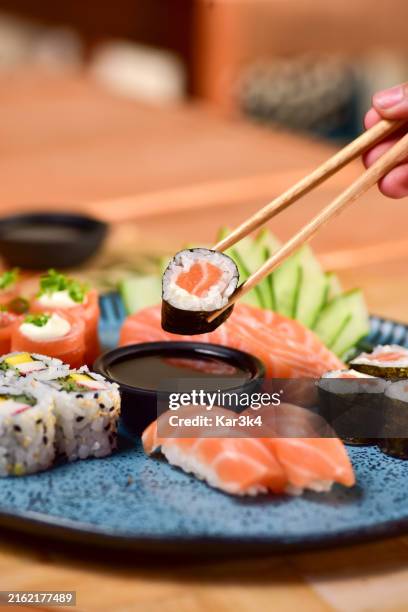 top eye view closeup of women left hand holding circle fresh salmon slices on japanese rice or sushi sashimi - japanese food stock pictures, royalty-free photos & images