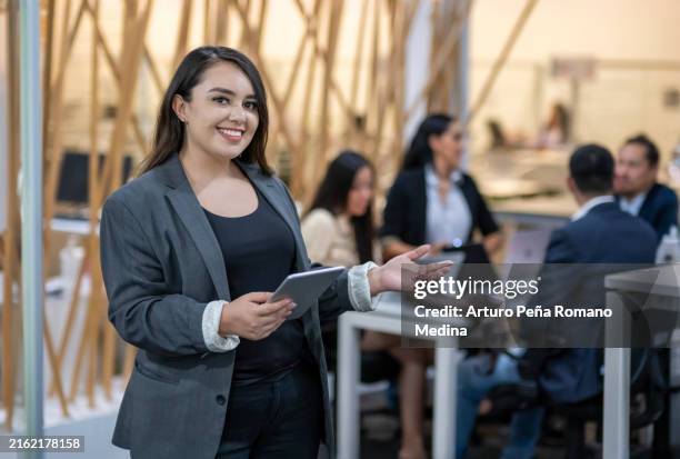 una mujer interactuando con la tecnología en el trabajo - social media fotografías e imágenes de stock