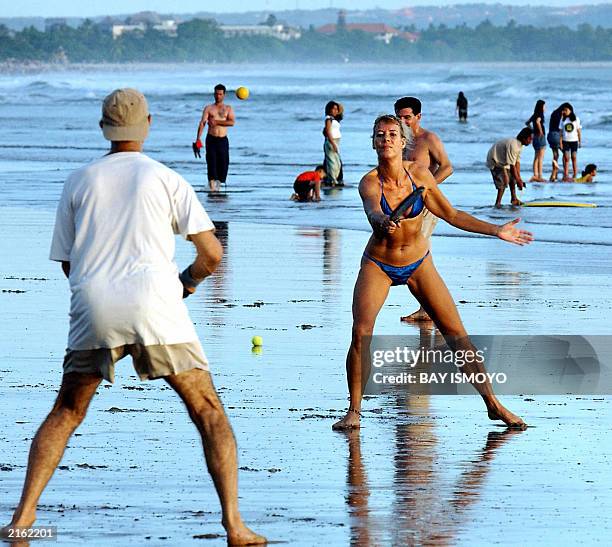 Foreign tourists play on Kuta beach near Denpasar on the resort island of Bali, 06 July 2003, as the area continues to recover from the devastating...