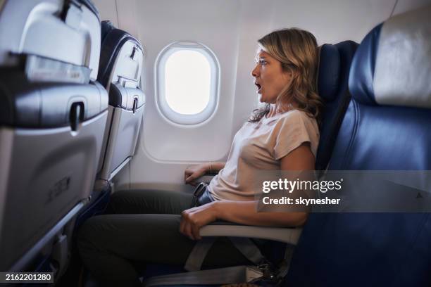 femme craintive voyageant en avion. - affolé photos et images de collection