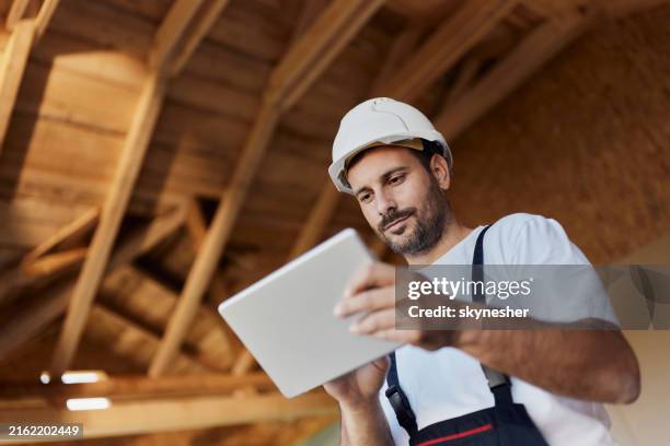 below view of manual worker using touchpad at construction site. - empreiteiro de reparações imagens e fotografias de stock