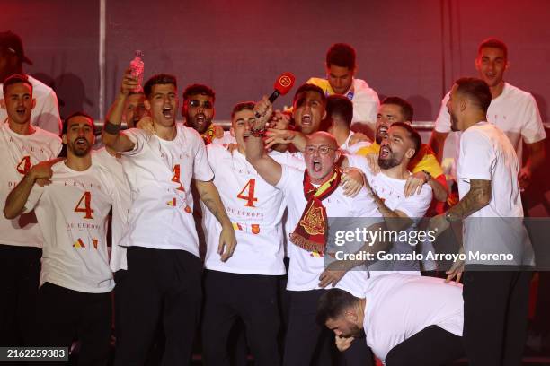 Luis de la Fuente, Head Coach of Spain holds the microphone surrounded by goalkeeper Unai Simon, Daniel Carvajal, Rordrigo, Fermin, Alvaro Morata and...
