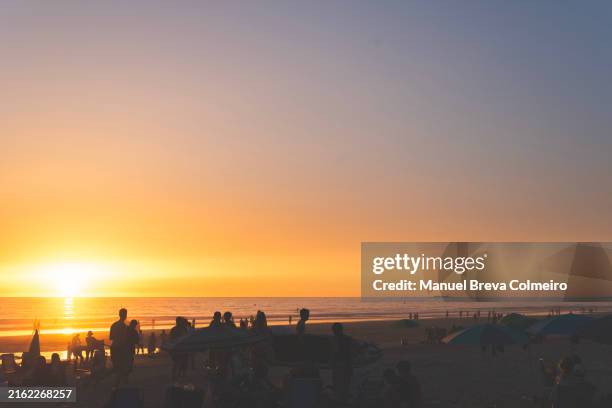 people enjoying the sunset in cádiz - costa de la luz stock-fotos und bilder