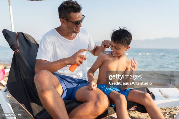 applying suntan lotion with fun - sun safety stock pictures, royalty-free photos & images