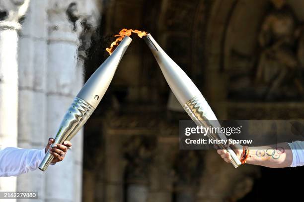 Claudia Tagbo, French-Ivorian actress and comedian and Pascal Touitou carry the Olympic Torch at Basilique du Sacre-Coeur de Montmartre during the...