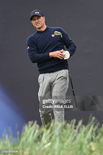 Australia's Adam Scott watches his iron shot from the 1st tee during his final round, on day four of the 152nd British Open Golf Championship at...