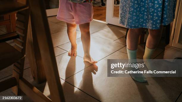 two children walk on a tiled floor - barefoot stock pictures, royalty-free photos & images