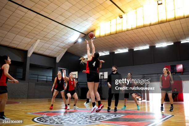 basketteuses professionnelles s’entraînant sur un terrain intérieur - basket ball féminin photos et images de collection