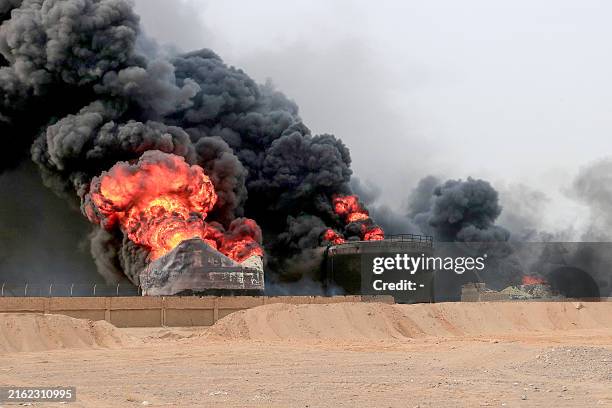 Thick smoke billows from a raging fire at oil storage tanks a day after Israeli strikes on the port of Yemen's Huthi-held city of Hodeida on July 21,...