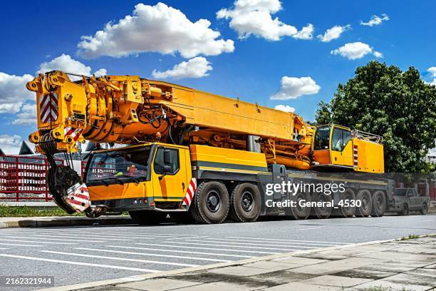 mobile cranes construction cranes with yellow telescopic arms and big tower cranes. - mobile crane stock pictures, royalty-free photos & images