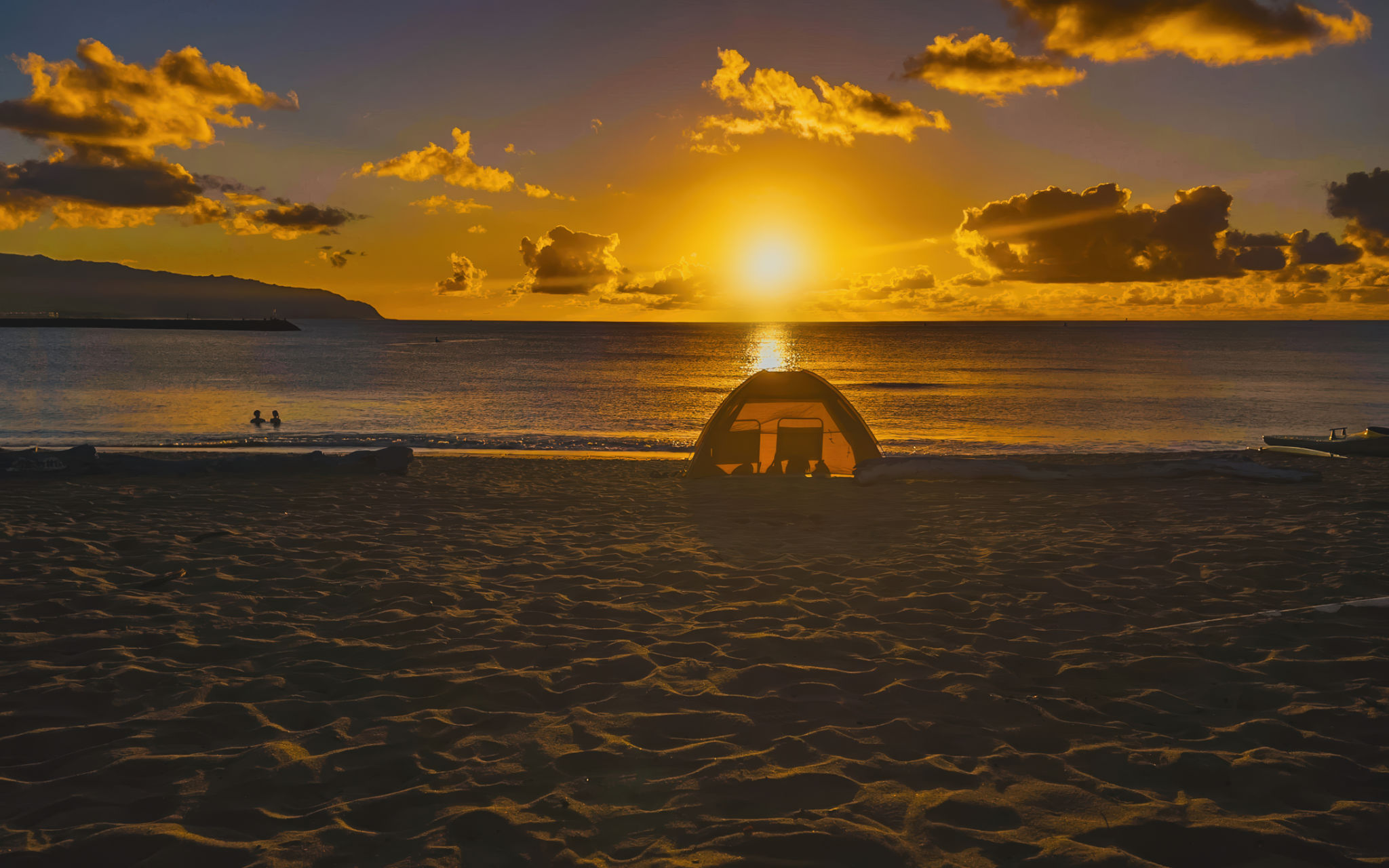 A serene sunset at the beach with golden hour and silhouette and dramatic sky with a few clouds. A serene sunset at the beach with golden hour and silhouette and dramatic sky with a few clouds.