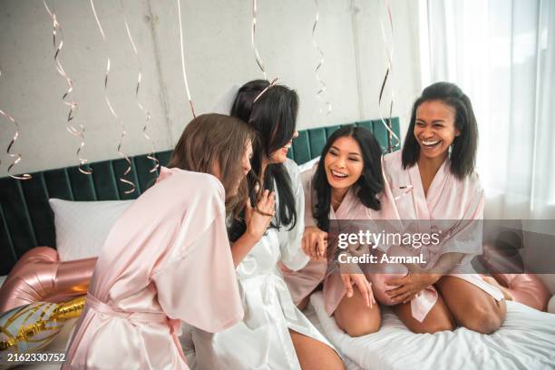 hispanische braut und verschiedene brautjungfern bei der vorbereitung auf den junggesellenabschied - übernachtungsparty stock-fotos und bilder