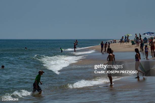 People swim in the water knowing there is always a risk a shark is around at Newcomb beach in Wellfleet, Massachusetts on July 21, 2024. The...