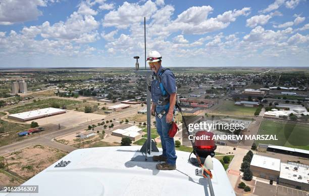 Wind turbine technician Terrill Stowe stands on the nacelle, which houses the gear box and generator of a wind turbine, on the campus of Mesalands...