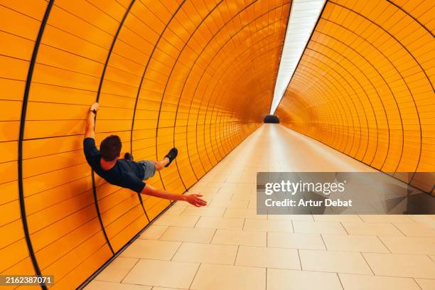 mind blowing picture of a guy playing with the tunnel perspective - ilusión óptica fotografías e imágenes de stock